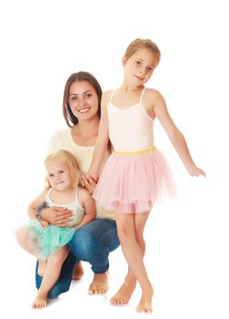 Beautiful young mother hugging 2 of their favorite daughters . Girls dressed in costumes of the dancers.Isolated on white.