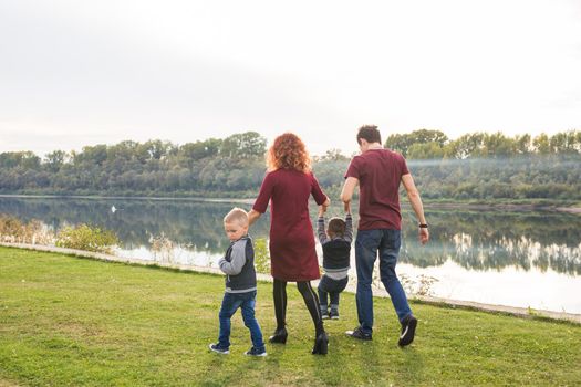 People and nature concept - Family walking by the water.