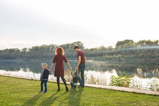 People and nature concept - Family walking by the water.