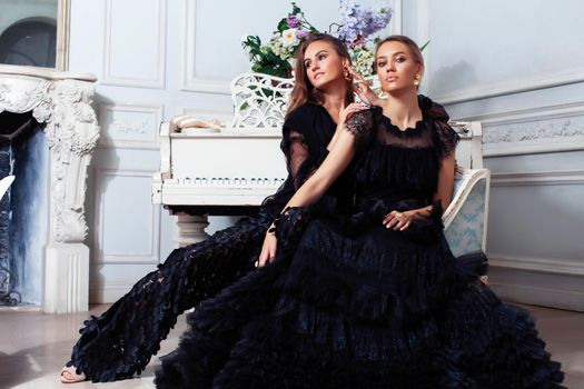 two young pretty lady in black lace fashion style dress posing in rich interior of royal hotel room, luxury lifestyle people concept closeup