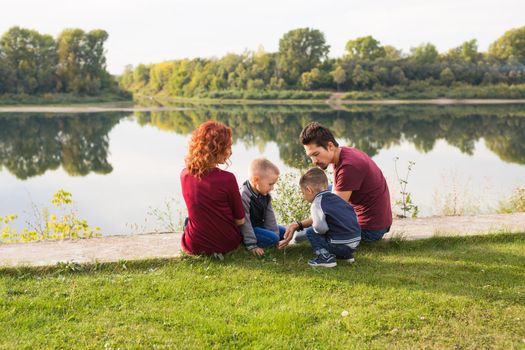 Children, parenthood and nature concept - Big family lying on the grass.