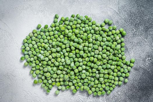 Raw Frozen green peas on kitchen table. White background. Top view.