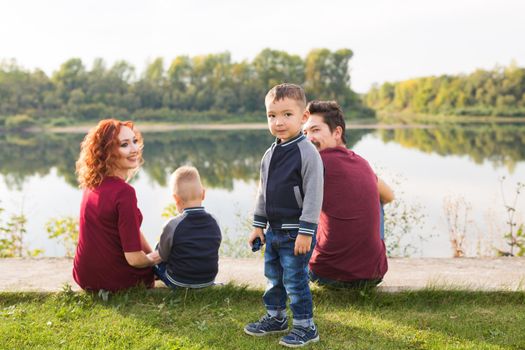 Children, parenthood and nature concept - Big family lying on the grass.