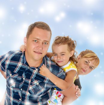 Portrait of happy family of three. Happy mother and daughter peeking from behind dad. close-up.Blue Christmas festive background with white snowflakes.