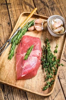 Raw fresh veal fillet meat steak with herbs. wooden background. Top view.