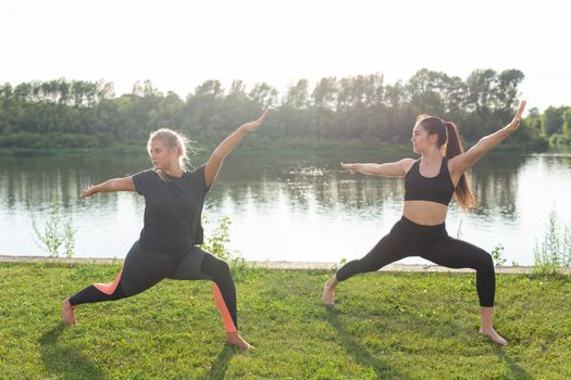 Healthy lifestyle and harmony concept - Young girls doing yoga outdoor.