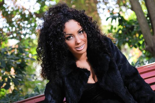 Portrait of a young black woman, model of fashion in a garden