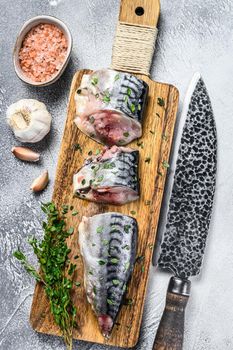 Sliced salted mackerel fish on a wooden cutting board. White background. Top view.