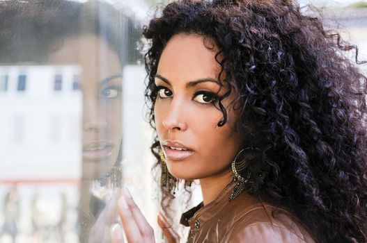 Portrait of a young black woman, afro hairstyle, in urban background