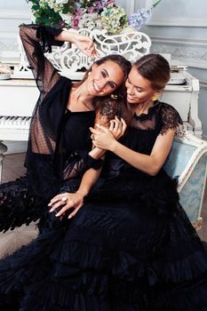 two young pretty lady in black lace fashion style dress posing in rich interior of royal hotel room, luxury lifestyle people concept closeup