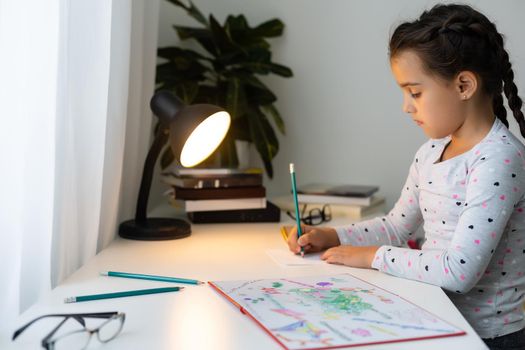 a child girl doing homework writing and reading at home