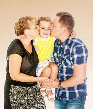 The parents are raised at the hands of his little daughter. And gently kiss her cheek.On a brown gradient background.