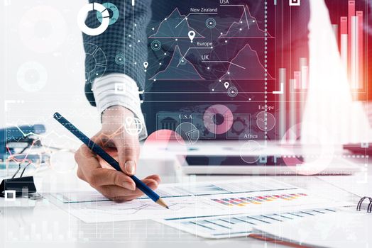 Businesswoman standing near office desk and analyzing financial charts. Successful corporate manager in business suit. Close-up woman hand with pen. Entrepreneurship double exposure concept.