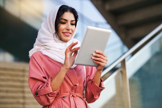 Young Muslim woman wearing hijab headscarf using digital tablet in business environment