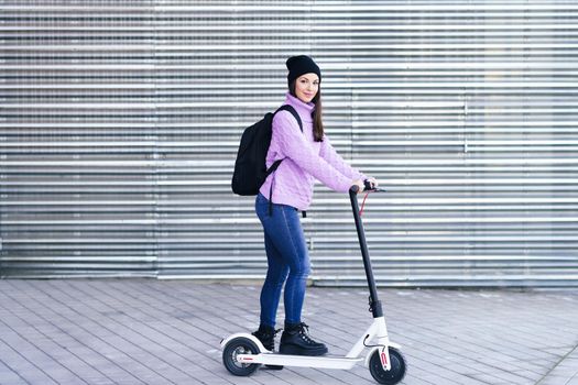 Young woman in her twenties riding an electric scooter. Lifestyle concept.