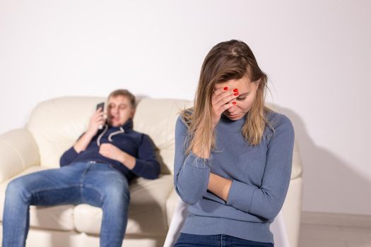 domestic violence, abuse and family concept - crying woman and her husband on the background.