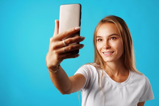 Happy casual young woman smiling and having a video call on smartphone