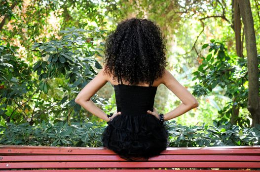 Portrait of a young black woman, model of fashion in a garden