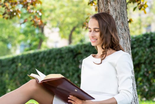 Beautiful young woman study with notepad in park