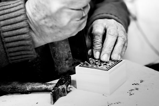 Close-up photgraph of a taracea craftsman working in his workshop