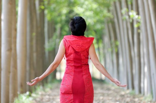 Woman dressed in red, meditating in the forest