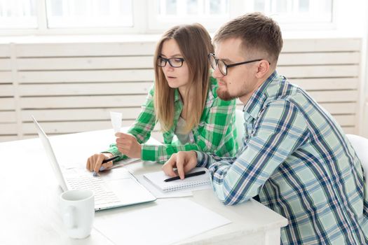 Husband and wife discuss amount in check for payment of the apartment and compare it with the rates on official website while sitting at the table with laptop. Concept of payment of utility bills