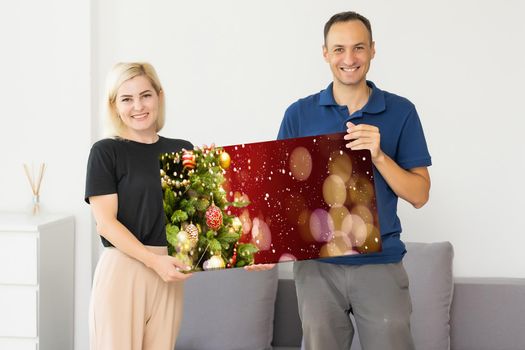 family holding photo canvas with christmas picture.
