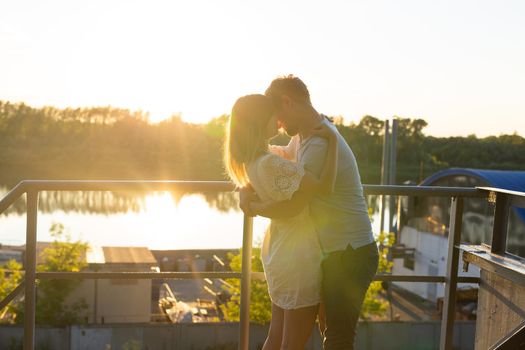 Man and woman hugging in sunset on nature. Couple in romantic embrace.