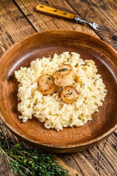 Italian Risotto with Scallops in a pan. wooden background. Top view.