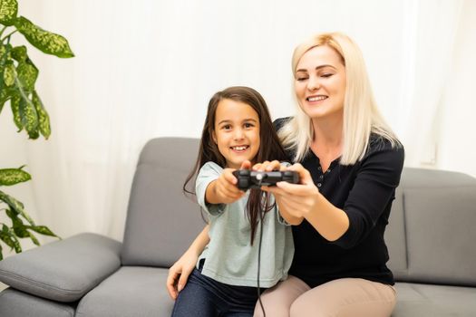 happy family together. mother and her child girl playing video games. family relax.