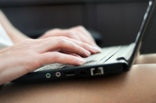 woman's hands typing on a laptop