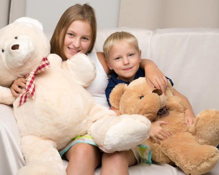 A teenage girl with her younger brother. studio photo session. The concept of family happiness.