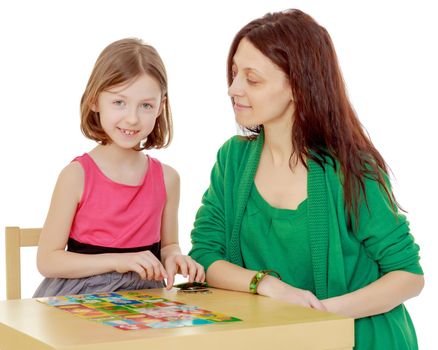 Clever little girl and her teacher at the table laid out cards with pictures.Isolated on white background.