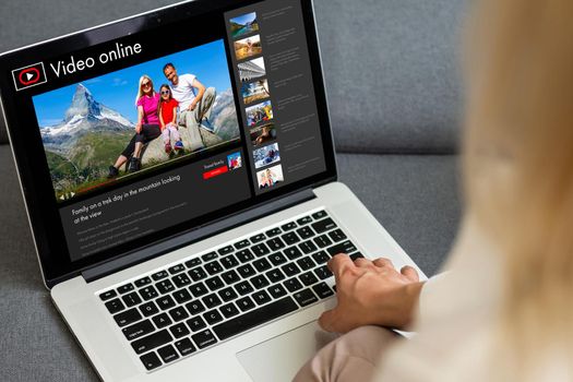 Woman watching videos online on laptop.