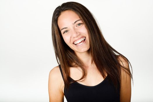 Beautiful young woman without make-up laughing. Beautiful girl with green eyes, model of fashion wearing black tank top on white background.