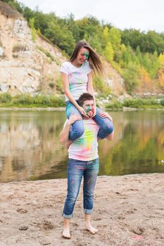 People, tourism and nature concept - Smiling couple with painted faces having fun.