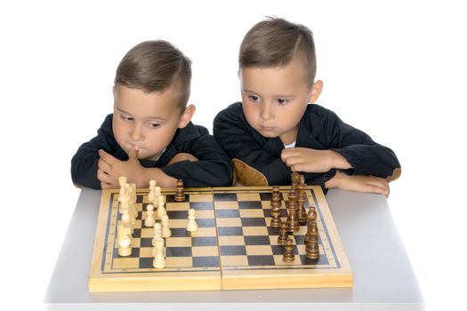 Two brothers are playing chess at home. Game, education, lifestyle concept.Isolated on white background