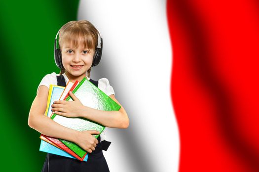 Happy young girl holding books, on the background of the flag of Italy. The concept of language learning and study. Travels.