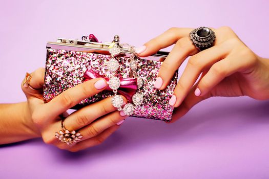 little girl stuff for princess, woman hands holding small cute handbag with jewelry and manicure, luxury lifestyle concept close up