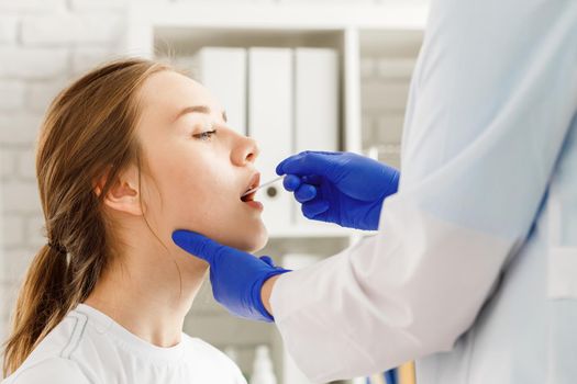 Doctor taking a throat swab from a patient to test for possible coronavirus infection