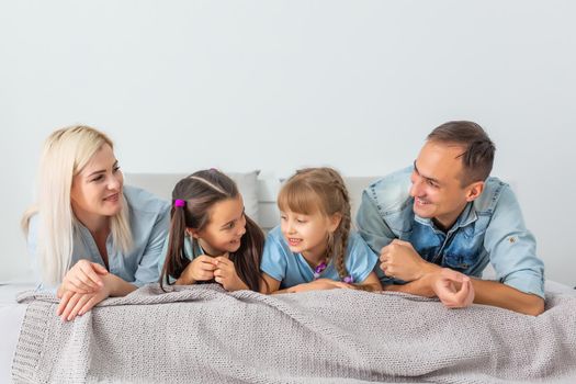 Happy family lying on a bed together in the bedroom
