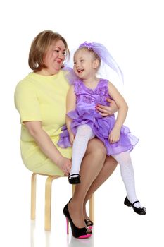 Young blonde mother, gently hugs her favorite little round-faced daughter. Family Idyll.Isolated on white background.