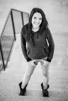 Portrait of brunette young woman with green eyes, wearing casual clothes, in urban background
