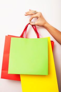woman hand holding few paper bags on white background isolated, shopping sale concept close up