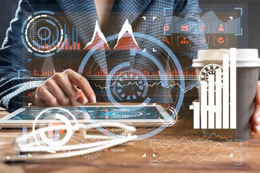 Businesswoman using tablet computer at wooden desk. Close up woman hand pointing on touchscreen. Business application with online financial analytics on screen of tablet device. Strategy planning