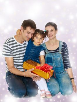 Happy young family with little daughter cuddling together in celebration of Christmas.Purple Christmas background with white snowflakes.
