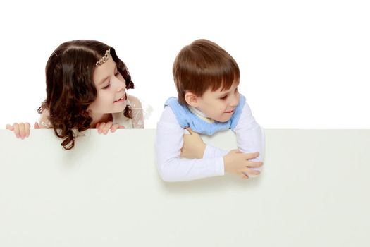 A boy and a girl peeping from behind the white banner.Children look to the side.isolated white background postprocessing cut