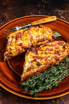 Hot baked sandwich on Baguette bread with ham, bacon, vegetables and cheese on a rustic plate. Dark background. Top view.