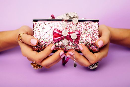 little girl stuff for princess, woman hands holding small cute handbag with jewelry and manicure, luxury lifestyle concept close up