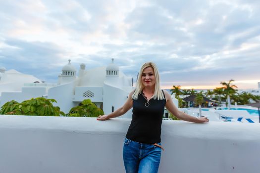 Young girl standing on the balcony overlooking the sea.